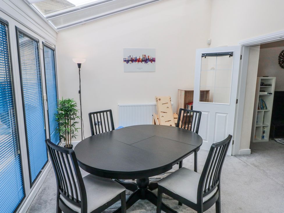 A conservatory with a round table and chairs at The Winster in Marple, Stockport