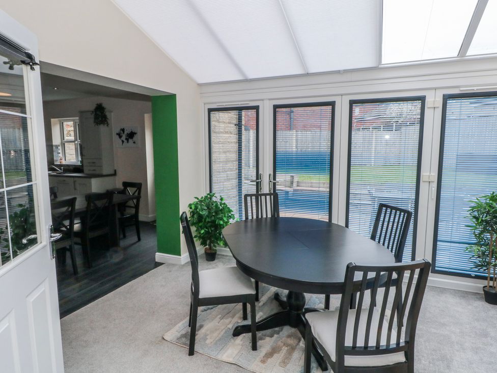A conservatory with a dining table and chairs at The Winster in Marple, Stockport