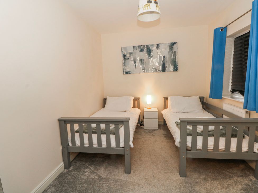A bedroom with two beds and a lamp on a nightstand at The Winster in Marple, Stockport