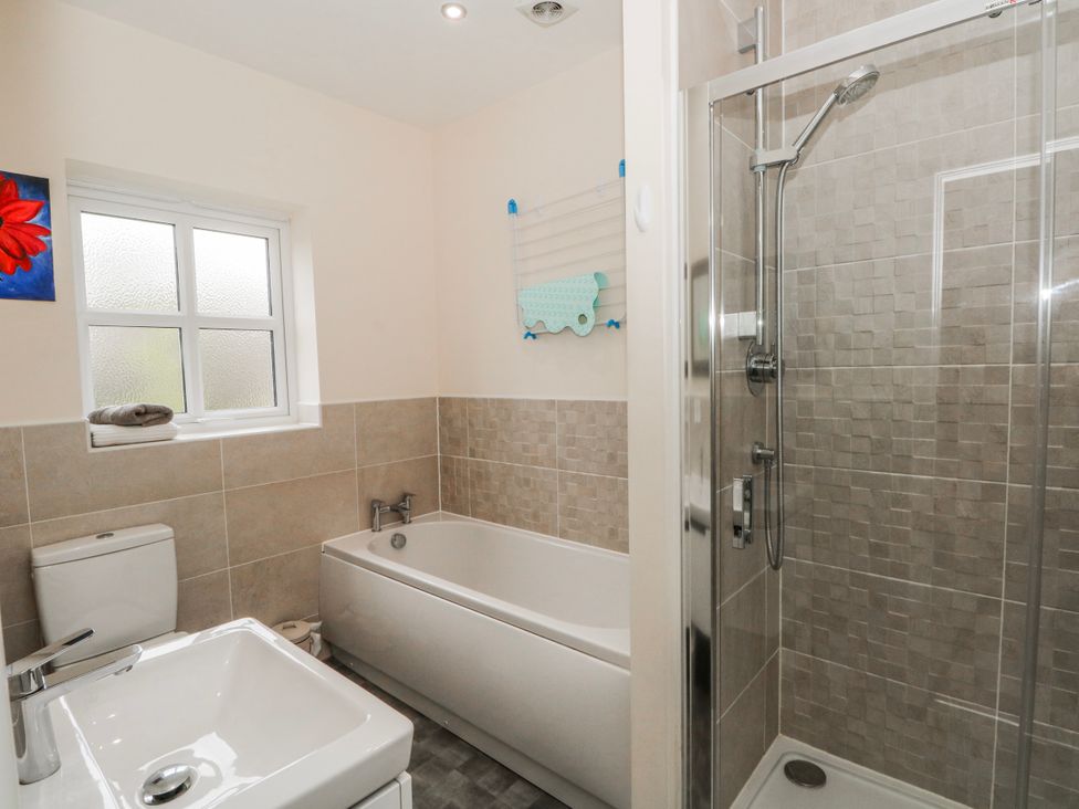 A bathroom with a bathtub, shower, toilet, and a sink at The Winster in Marple, Stockport