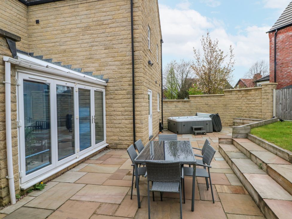 An outdoor seating area with a table and chairs next to a hot tub at The Winster in Marple, Stockport