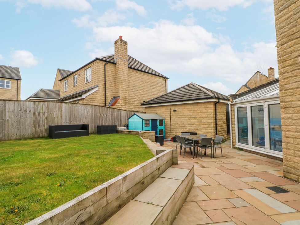 A garden with a lawn and seating area at The Winster in Marple, Stockport