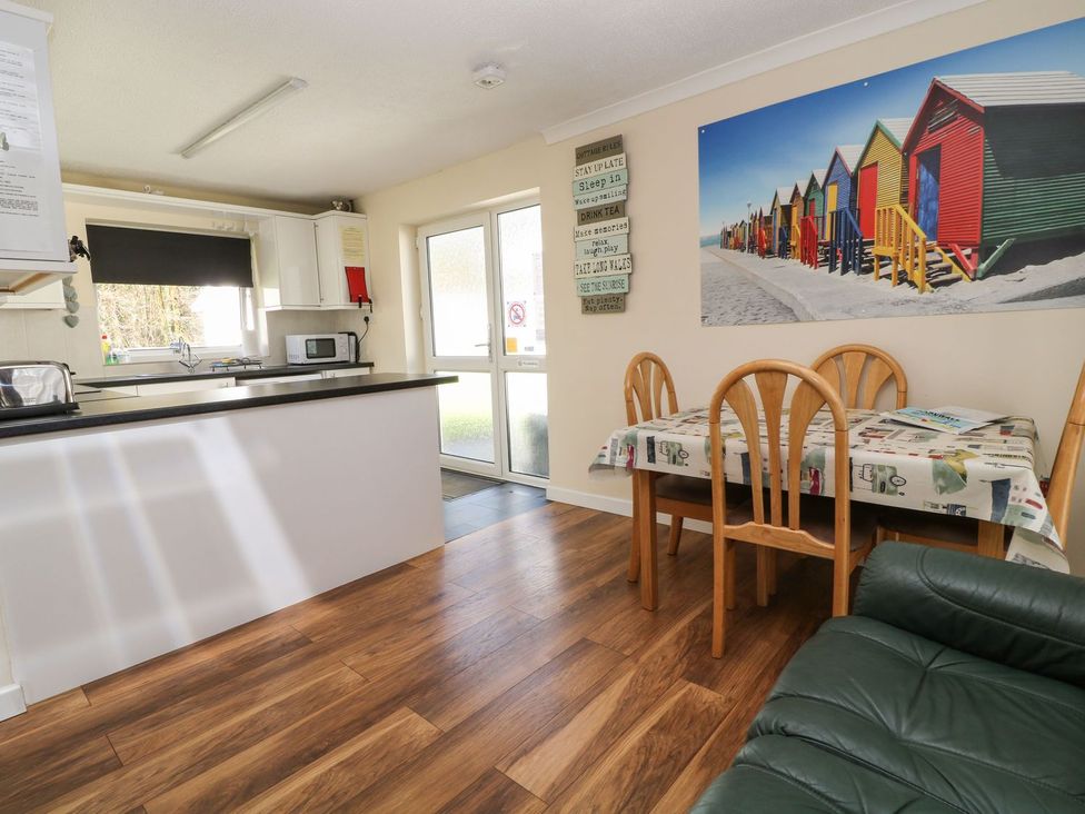 A kitchen with table and chairs at Willow Lodge in Liskeard
