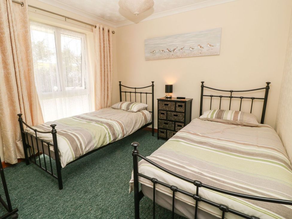 A bedroom with two single beds and a nightstand at Willow Lodge in Liskeard