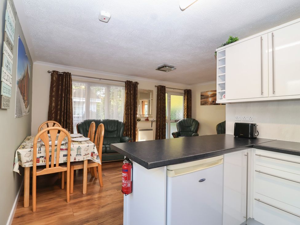 A kitchen with a dining table and chairs at Willow Lodge Rosecraddoc Lodge near Liskeard
