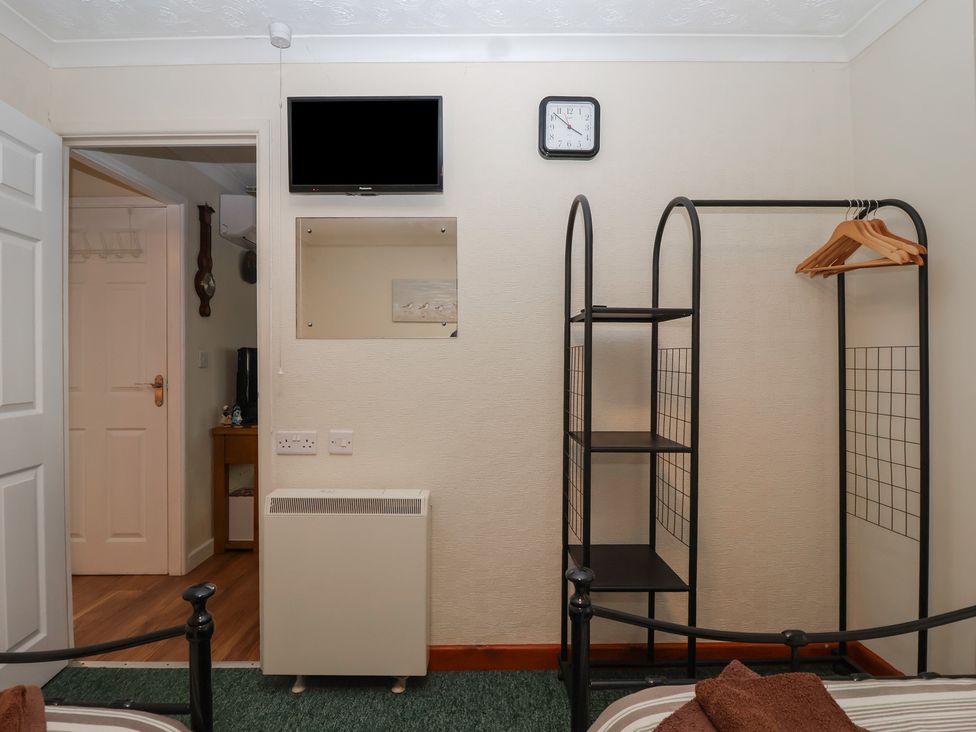 A bedroom with a television and a shelf at Willow Lodge near Liskeard