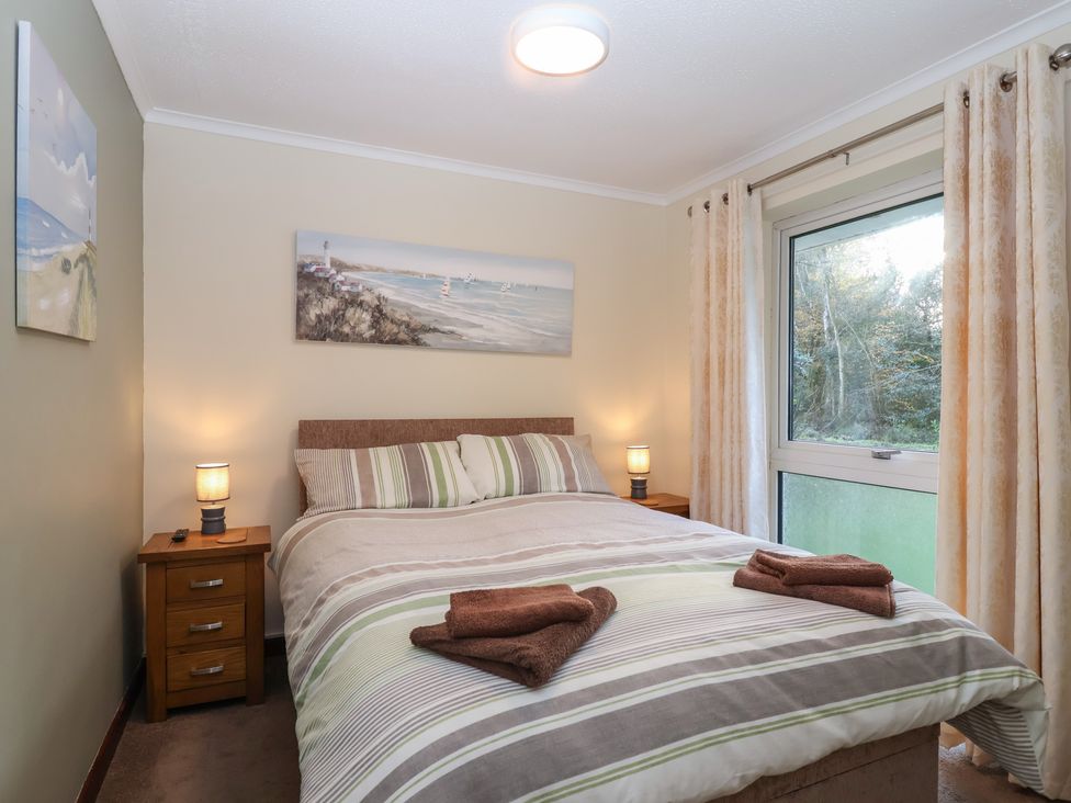 A bedroom with a bed and nightstand at Willow Lodge Rosecraddoc Lodge near Liskeard
