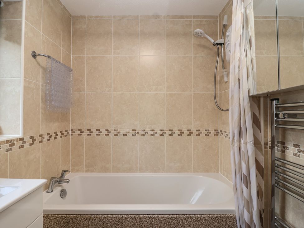 A bathroom with a bathtub and shower fittings at Willow Lodge near Liskeard