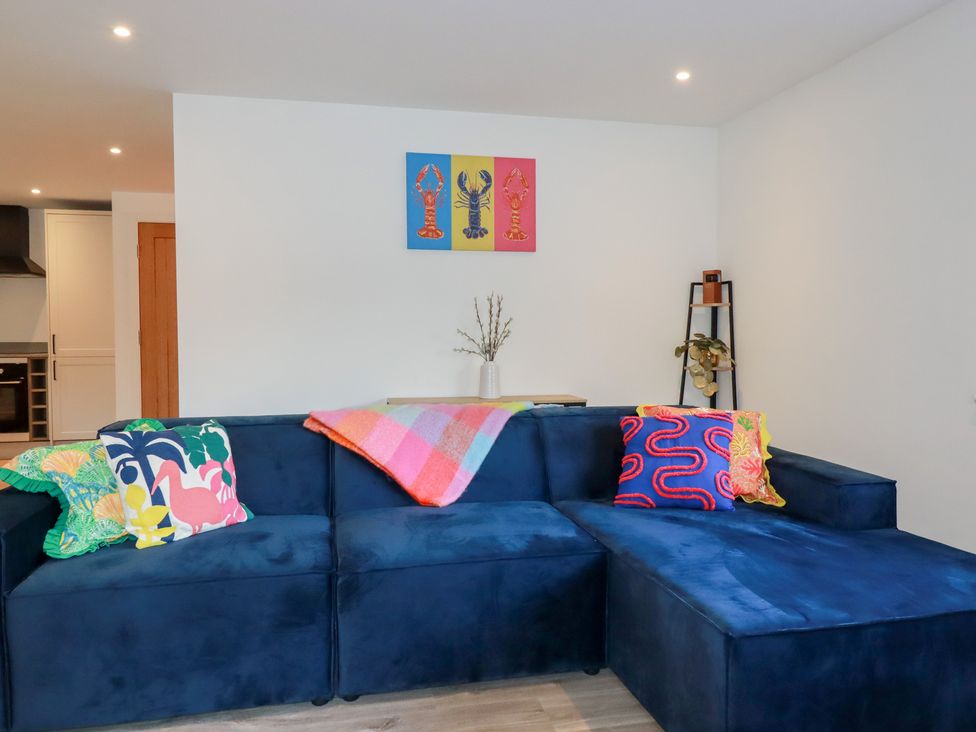 A living room with a blue sofa and colorful pillows at Barn 5