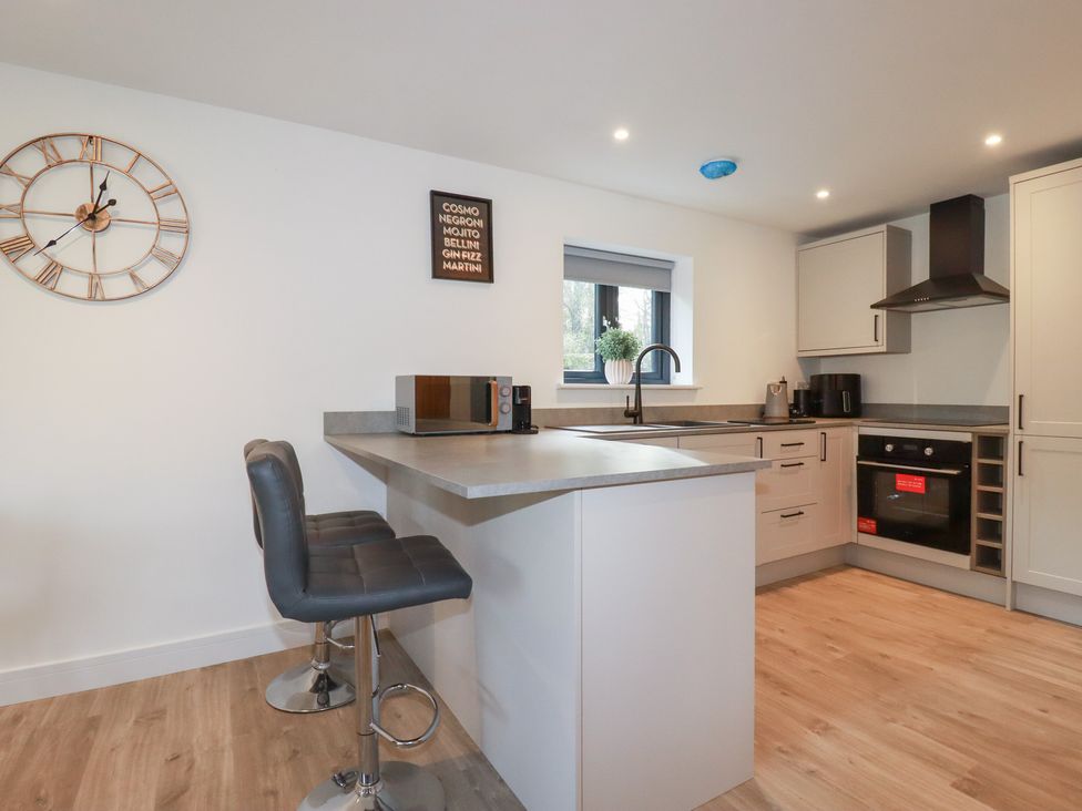 A kitchen with a microwave and bar stools at Barn 5 