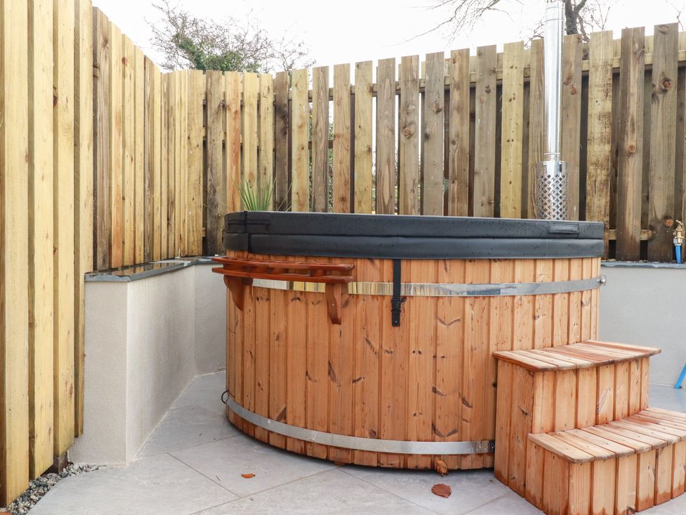 A hot tub with wooden steps in an outdoor space at Barn 5