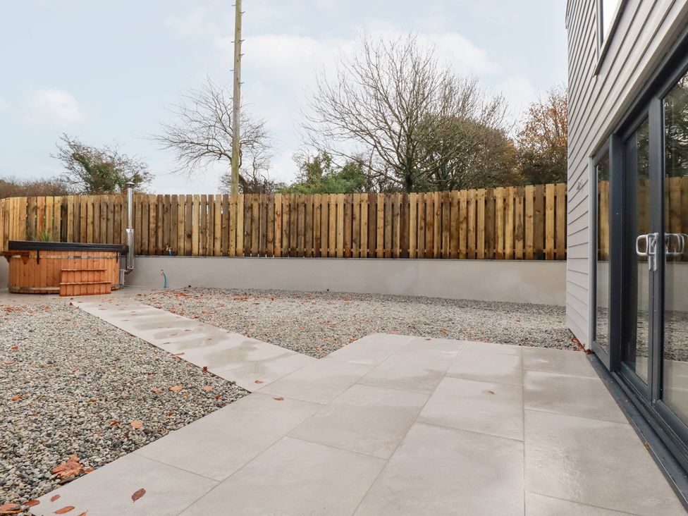 A garden with a hot tub and gravel pathway at Barn 5 