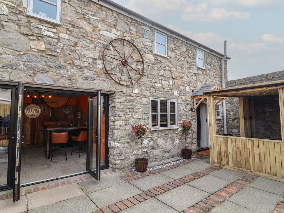 An outdoor area with a stone wall and seating at The Ranch in Prestatyn