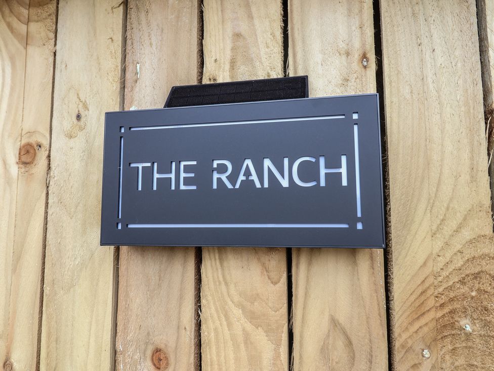 A sign displaying the name 'THE RANCH' on a wooden fence at The Ranch in Prestatyn