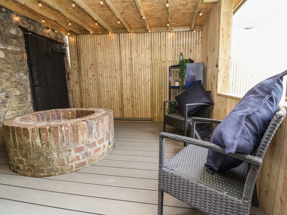 An outdoor seating area with a brick fire pit and chairs at The Ranch in Prestatyn