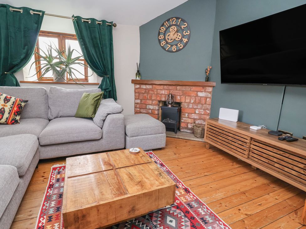 A living room with a sofa and television at The Ranch in Prestatyn