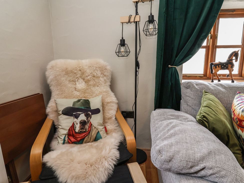 A living room with a chair and decorative items at The Ranch in Prestatyn