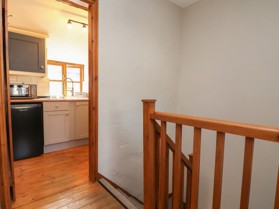 A staircase leading to a kitchen area at The Ranch in Prestatyn