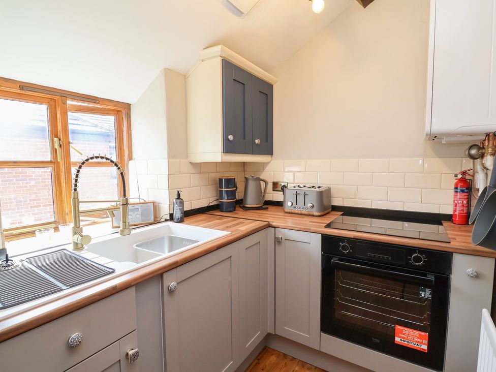 A kitchen with sink, oven, kettle, and toaster at The Ranch in Prestatyn