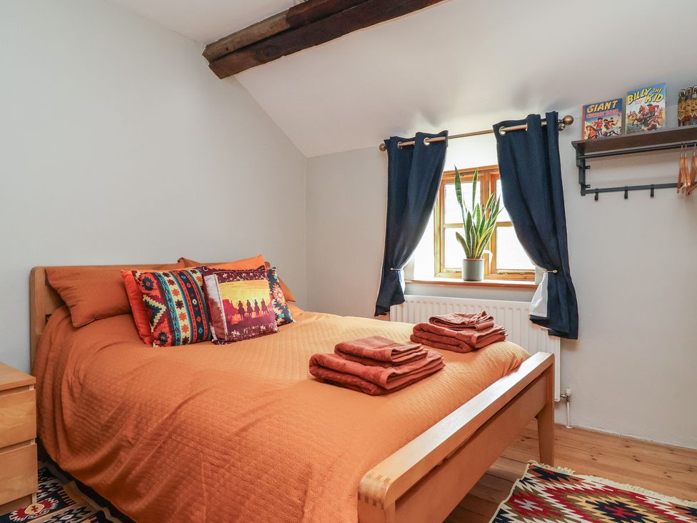 A bedroom with a bed and shelves at The Ranch in Prestatyn