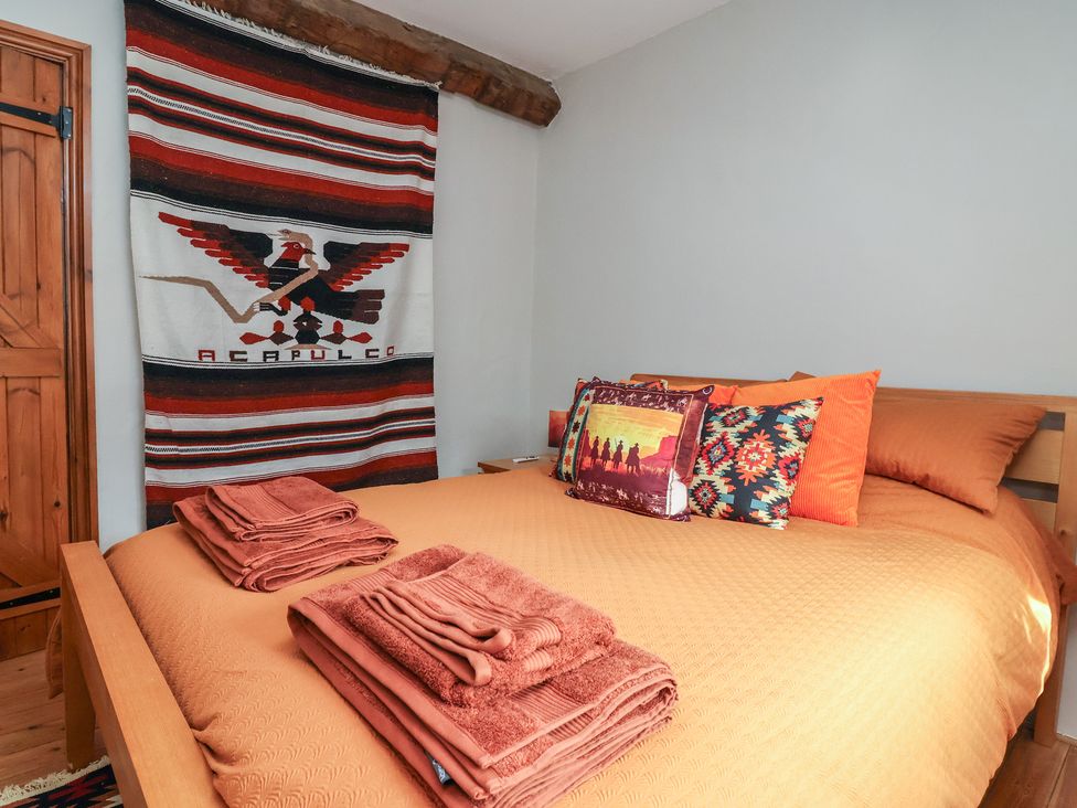 A bedroom with a bed and decorative pillows at The Ranch in Prestatyn