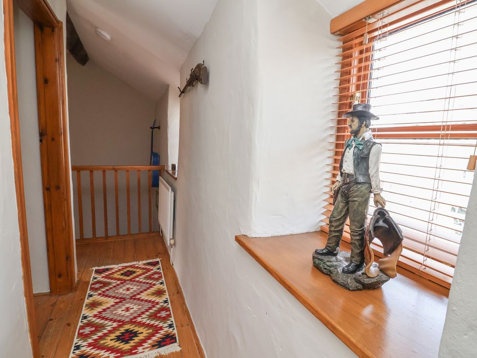 A hallway with a railing and a statue at The Ranch in Prestatyn