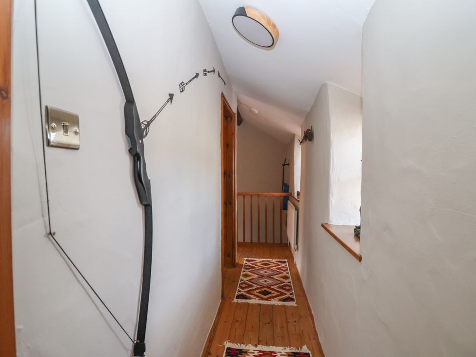 A hallway with wooden flooring and light fixture at The Ranch in Prestatyn