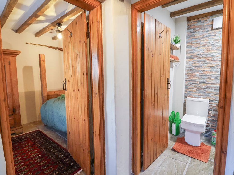 A bathroom with a toilet and a shelf at The Ranch in Prestatyn