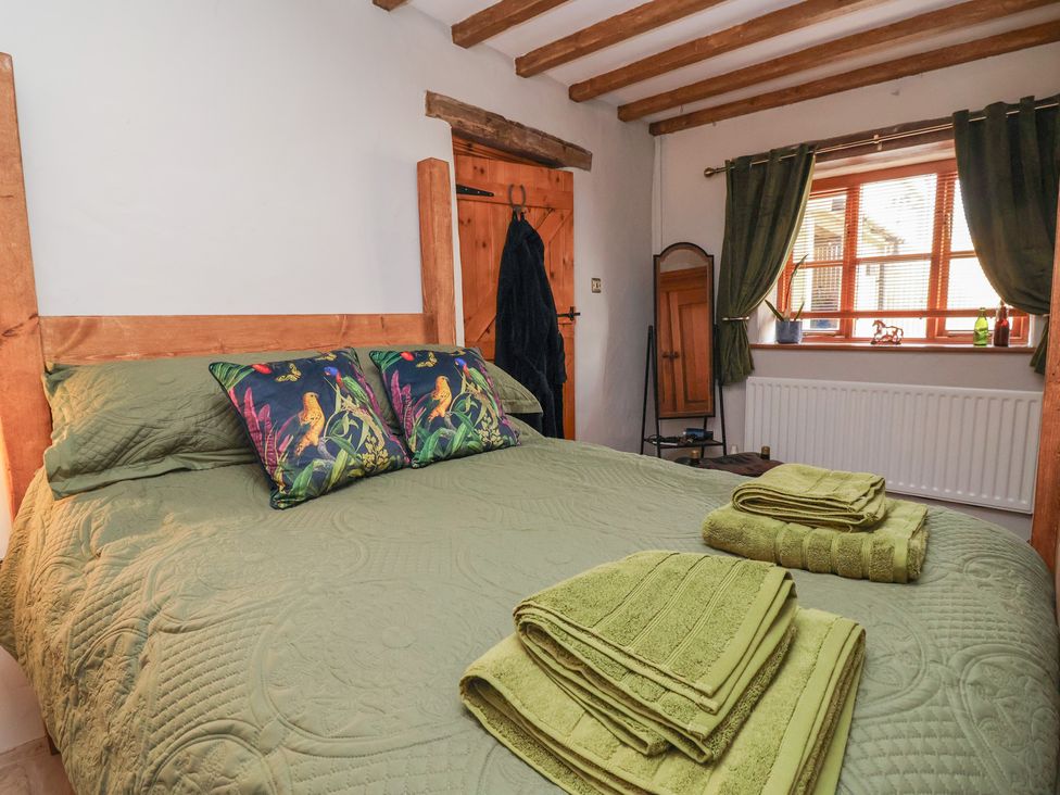 A bedroom with a bed and towels on the bed at The Ranch in Prestatyn