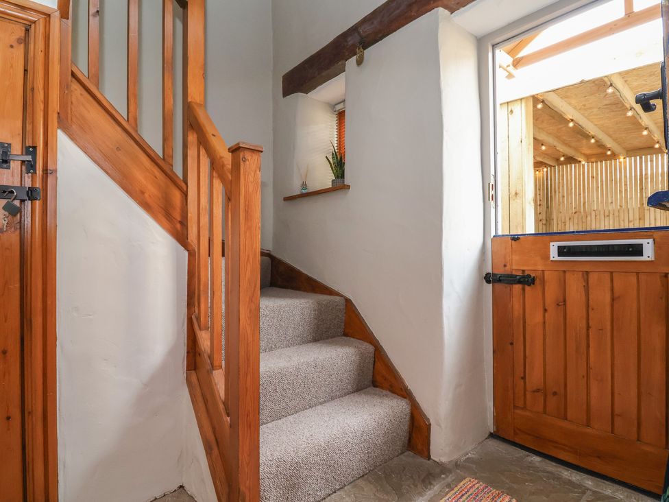 A staircase and wooden door in the hallway at The Ranch in Prestatyn