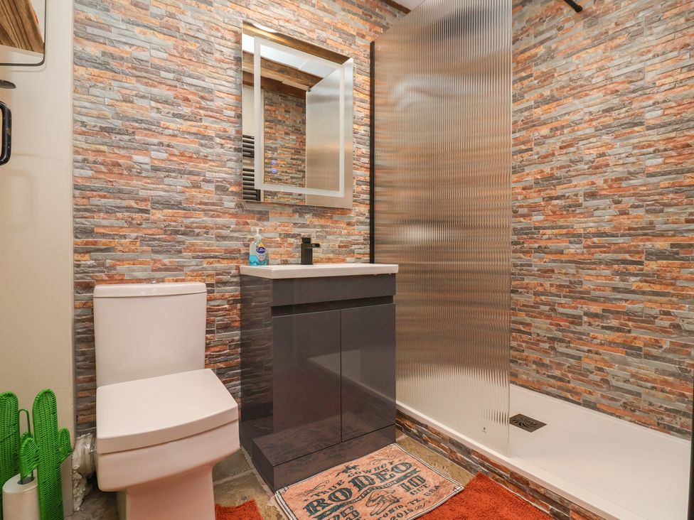 A bathroom with a toilet, sink, and shower at The Ranch in Prestatyn