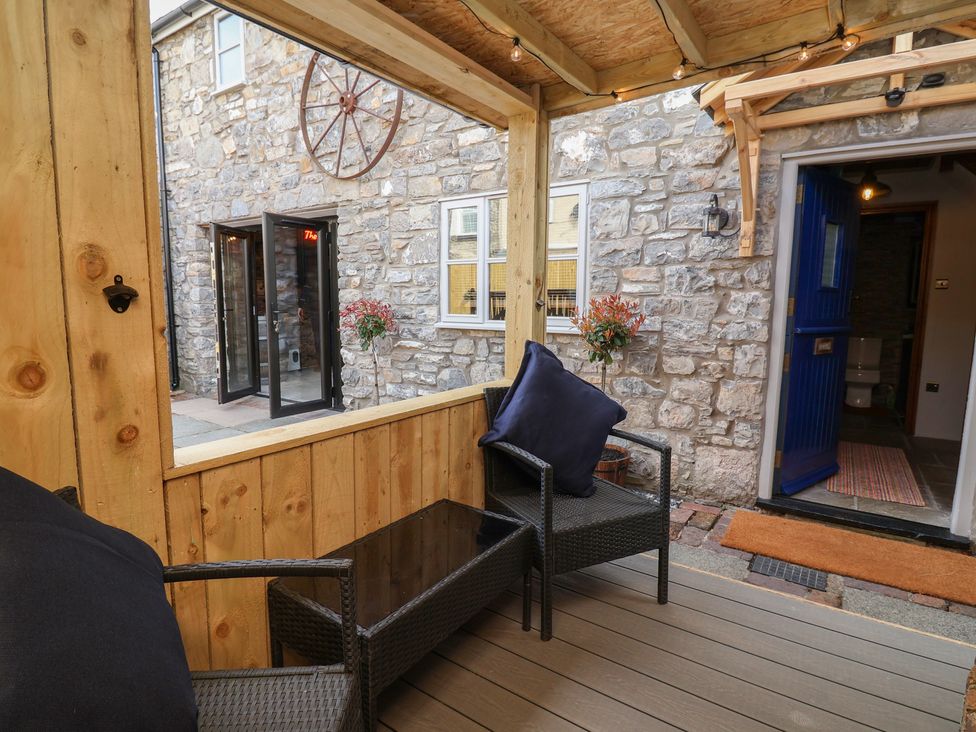 An outdoor seating area with a stone wall and a sliding door at The Ranch in Prestatyn