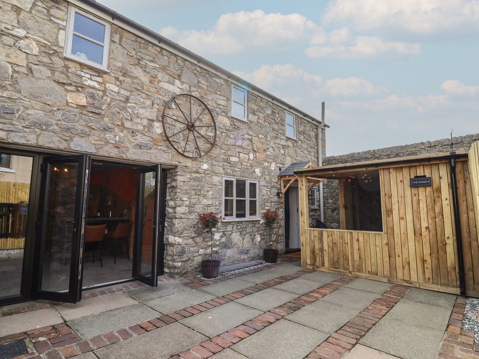 An outdoor area with a stone building and wooden structure at The Ranch in Prestatyn