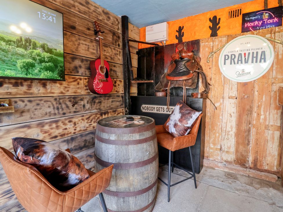 A bar with a barrel table and chairs at The Ranch in Prestatyn