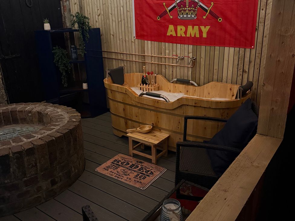 A spa area with a wooden bathtub and stone basin at The Ranch in Prestatyn