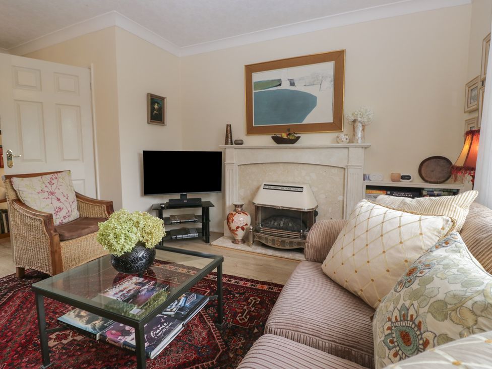 A living room with a fireplace and television at Apple Byrd in Kendal