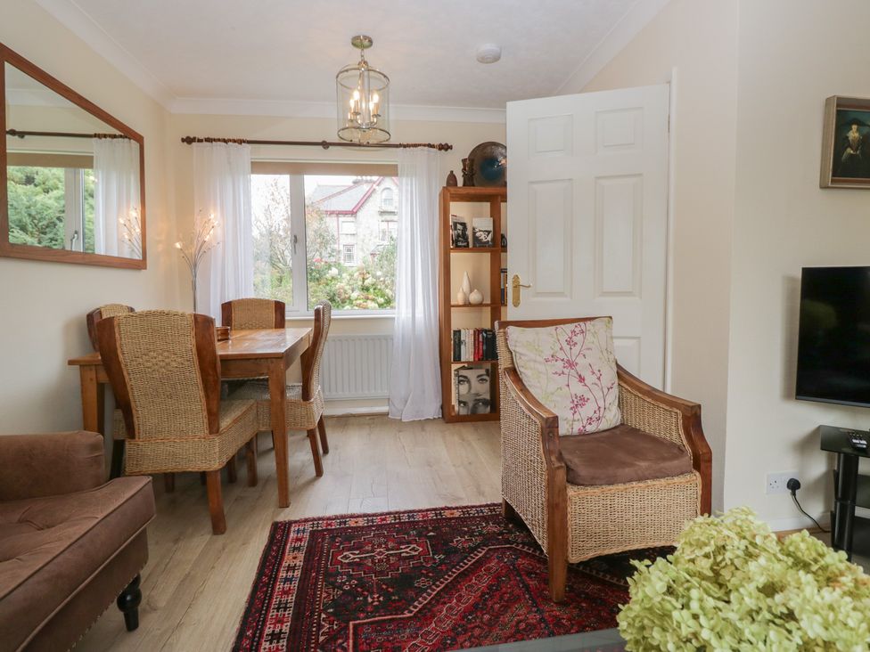 A living room with a dining area and armchair at Apple Byrd in Kendal