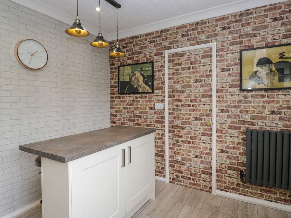 A kitchen with a countertop and pendant lights at Apple Byrd in Kendal