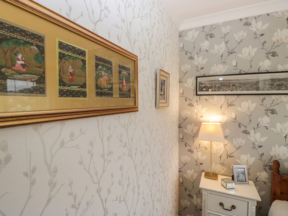 A bedroom with framed artwork and a lamp at Apple Byrd in Kendal