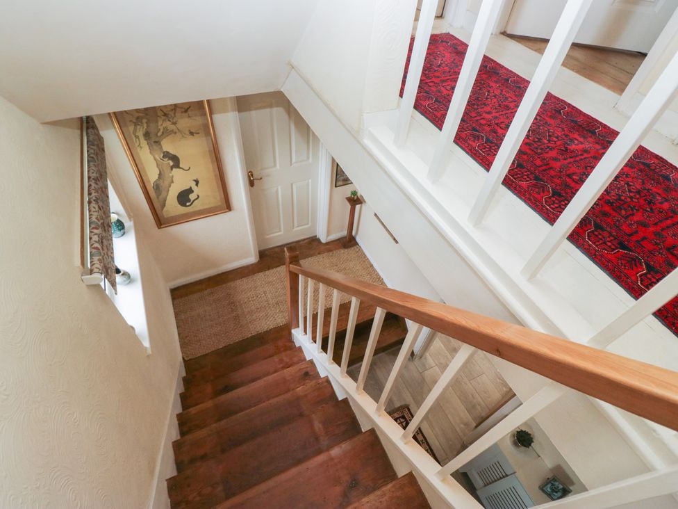 A staircase with a rug and artwork at Apple Byrd in Kendal
