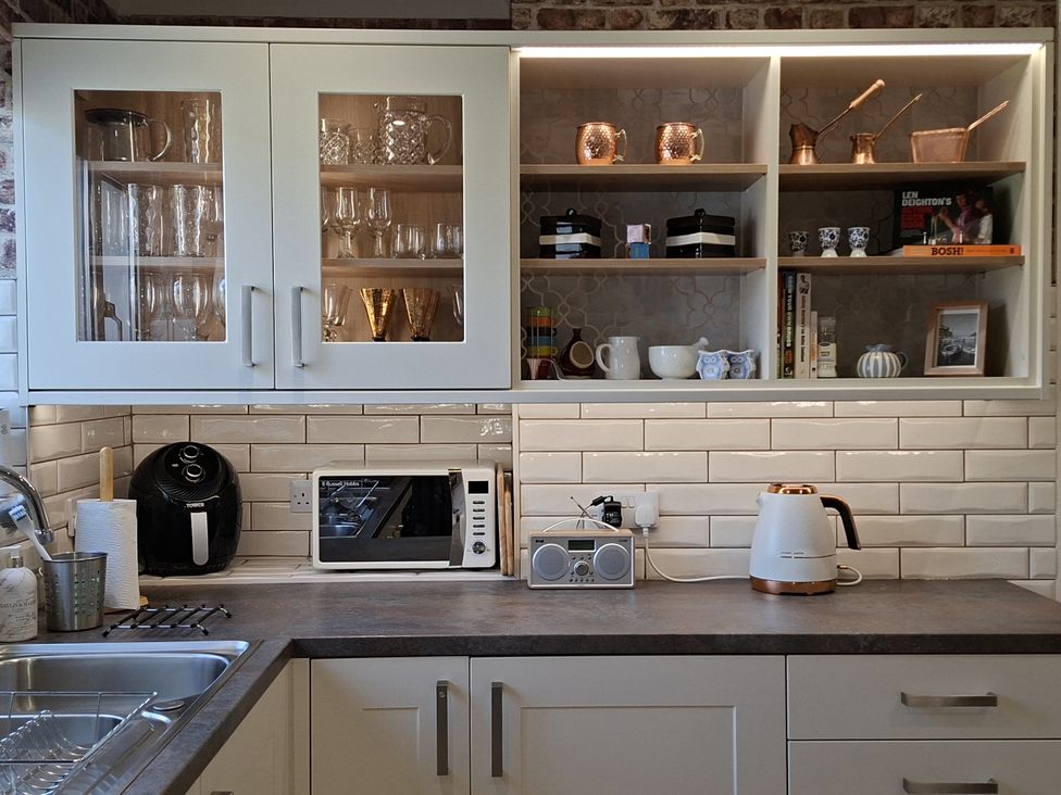 A kitchen with cabinets and appliances at Apple Byrd in Kendal