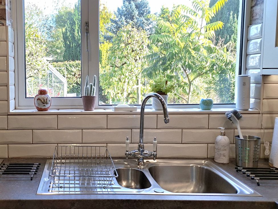 A sink with a faucet and dish rack near a window at Apple Byrd in Kendal