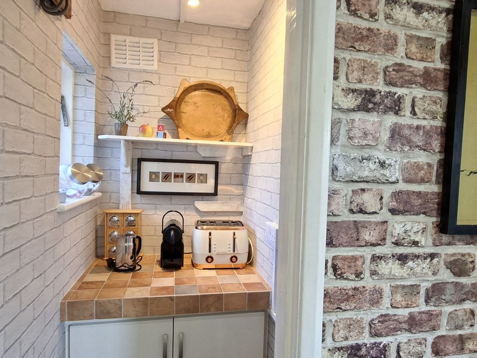 A kitchen area with kitchen appliances and decorative items at Apple Byrd in Kendal