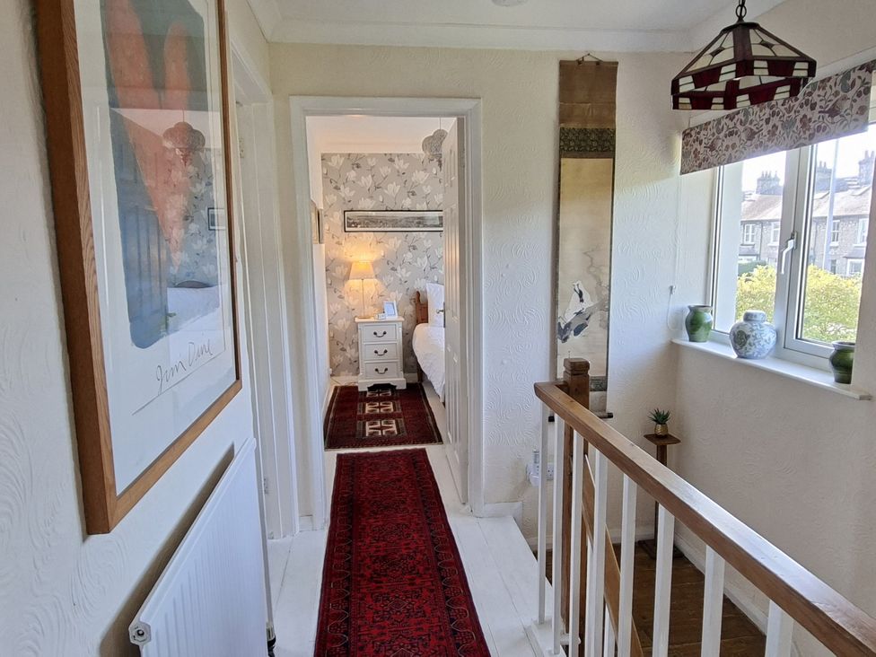 A hallway leading to a bedroom with a lamp and dresser at Apple Byrd in Kendal