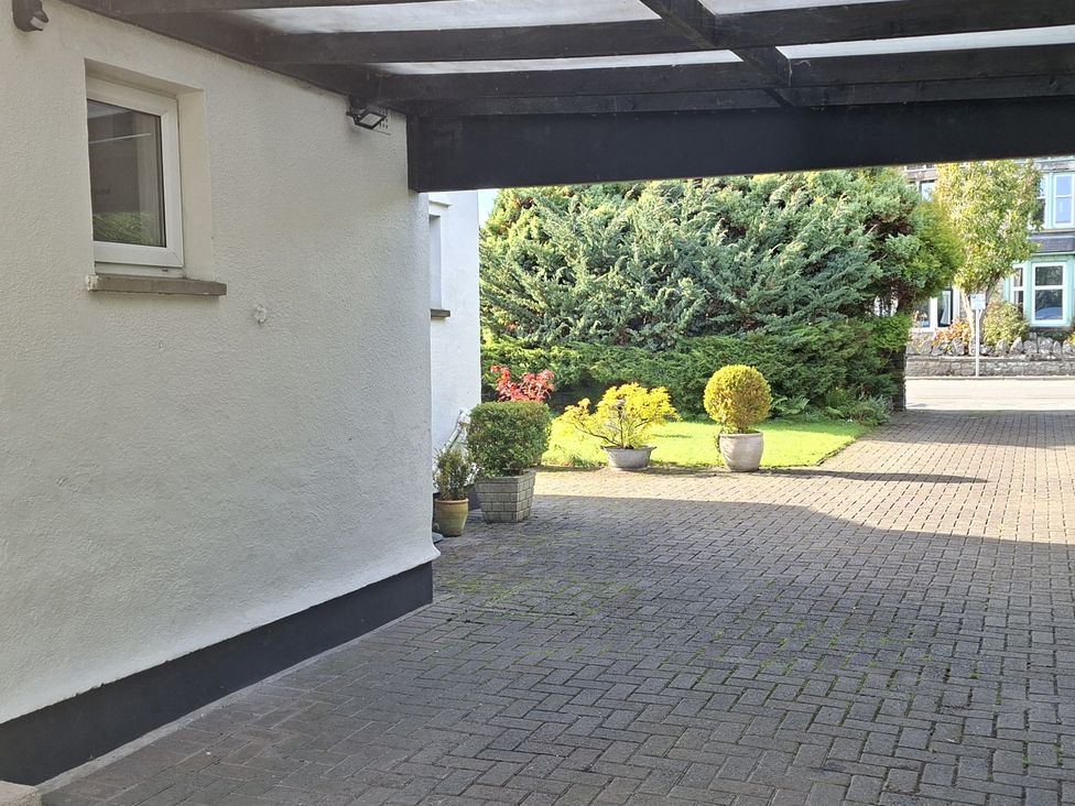 A garden with potted plants and paved area at Apple Byrd in Kendal