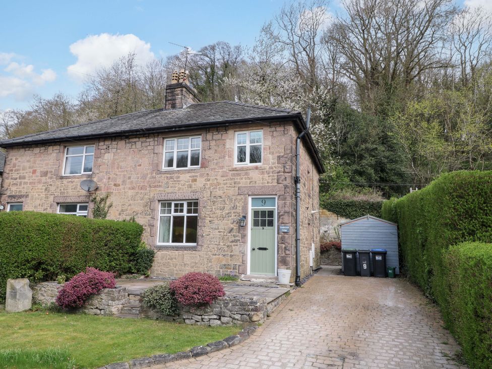 An exterior view of a stone house with a driveway and garden at 9 New Lumford
