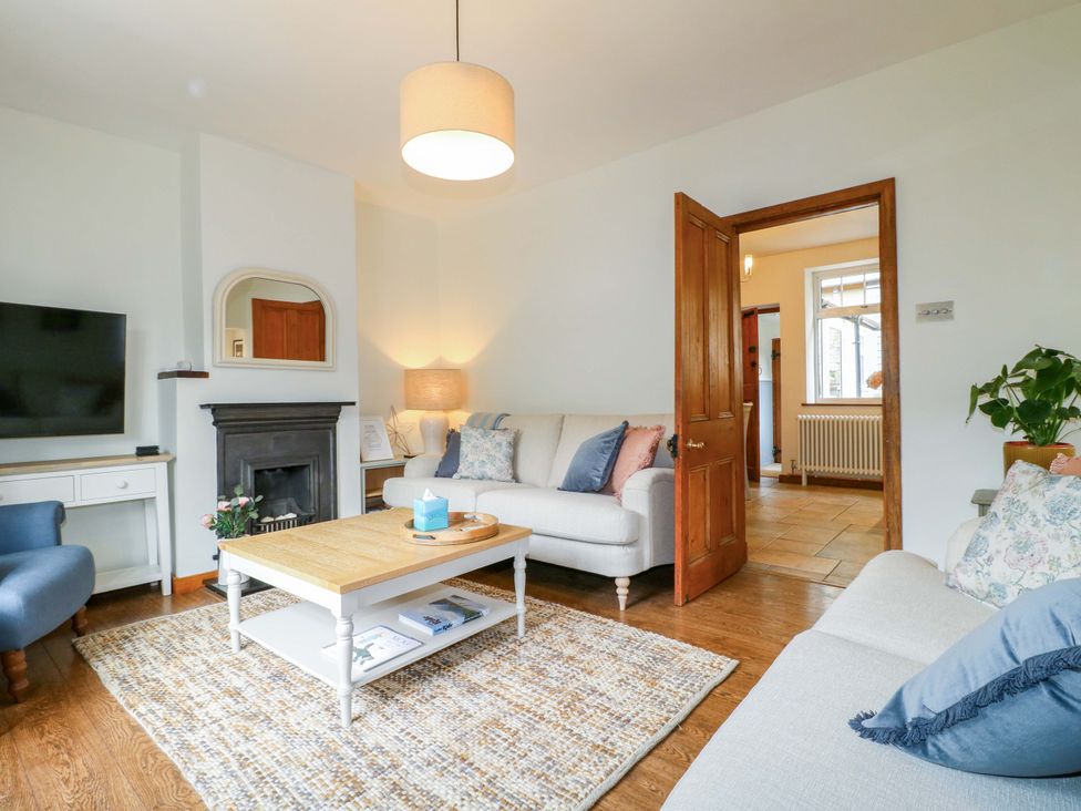 A living room with a sofa, coffee table, and television at 9 New Lumford