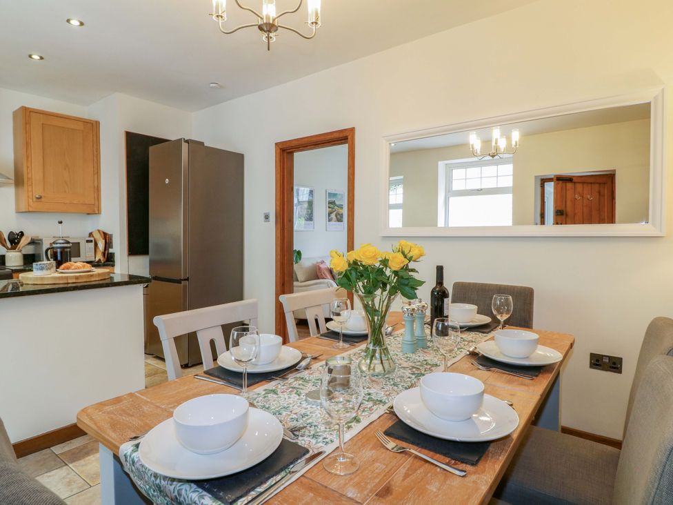 A dining area with a table set for meals at 9 New Lumford
