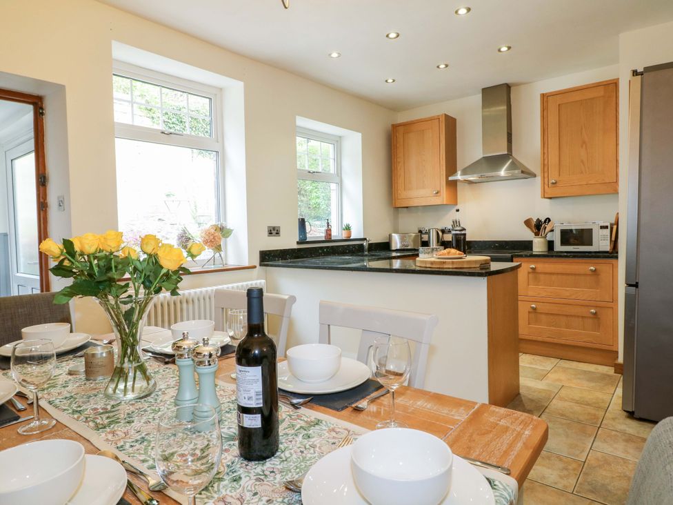 A kitchen with a dining table set for a meal at 9 New Lumford