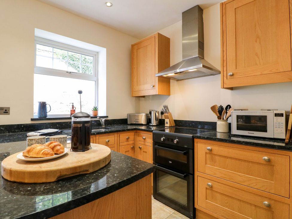 A kitchen with countertops, appliances, and a cutting board at 9 New Lumford